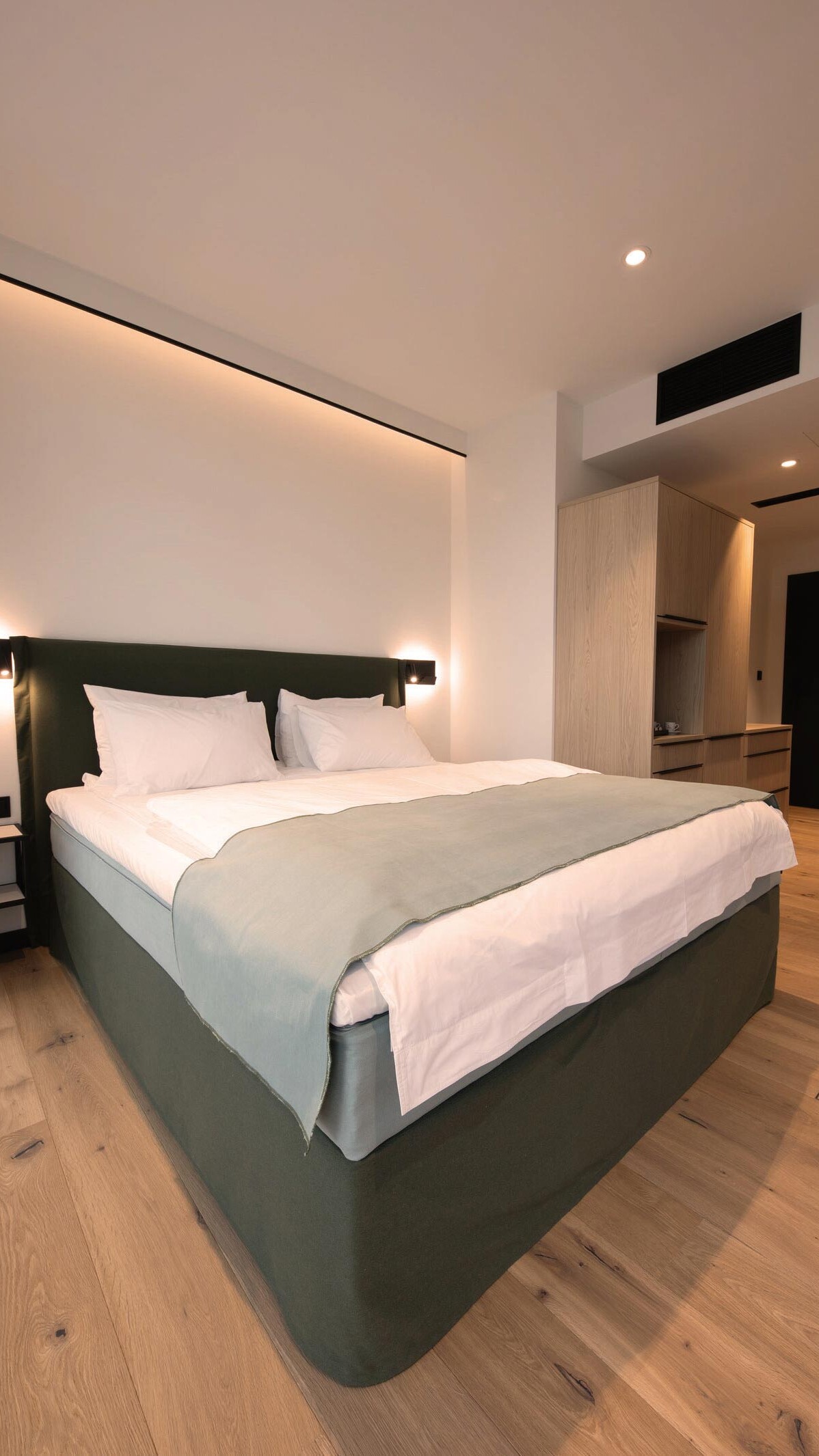 Doppelbett in großzügig geschnittenem Hotelzimmer