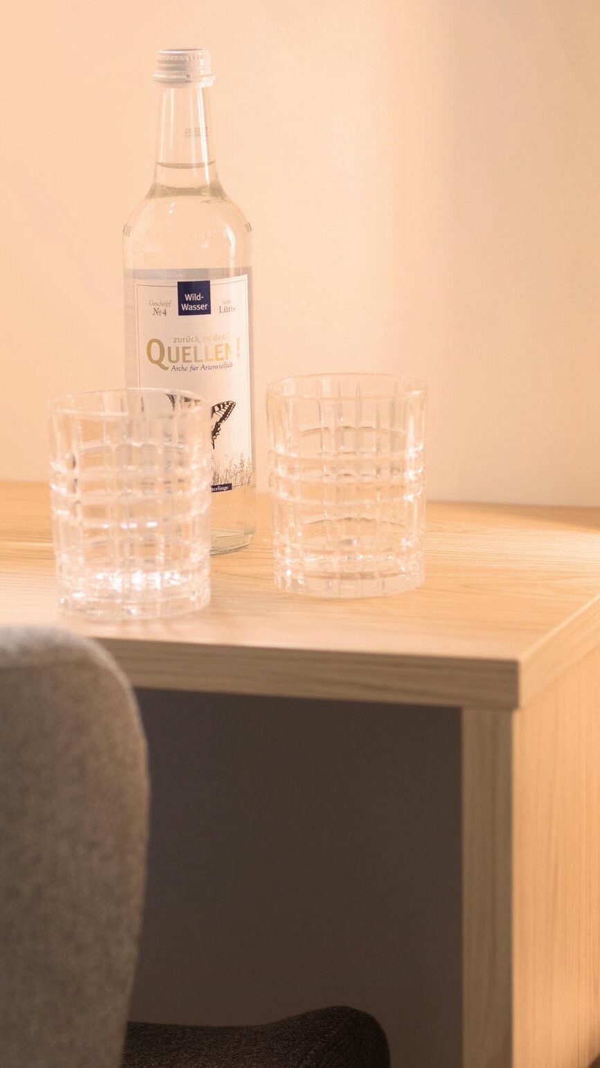 Wasserflasche und Gläser auf einem Schreibtisch