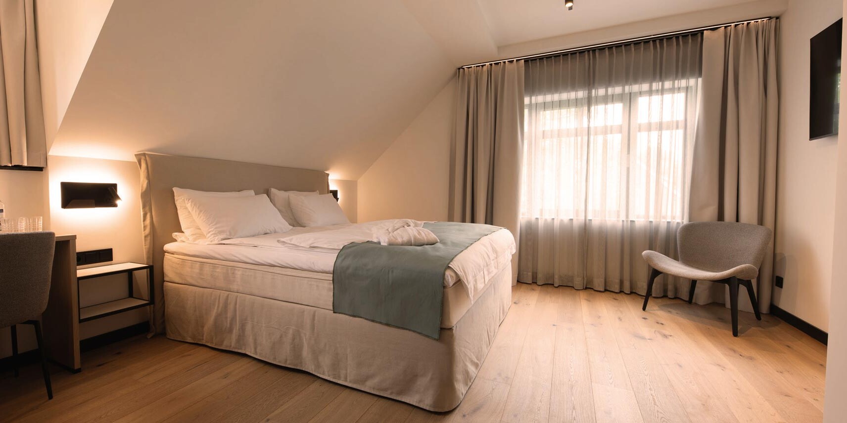 großes Hotelzimmer mit Parkettboden und TV