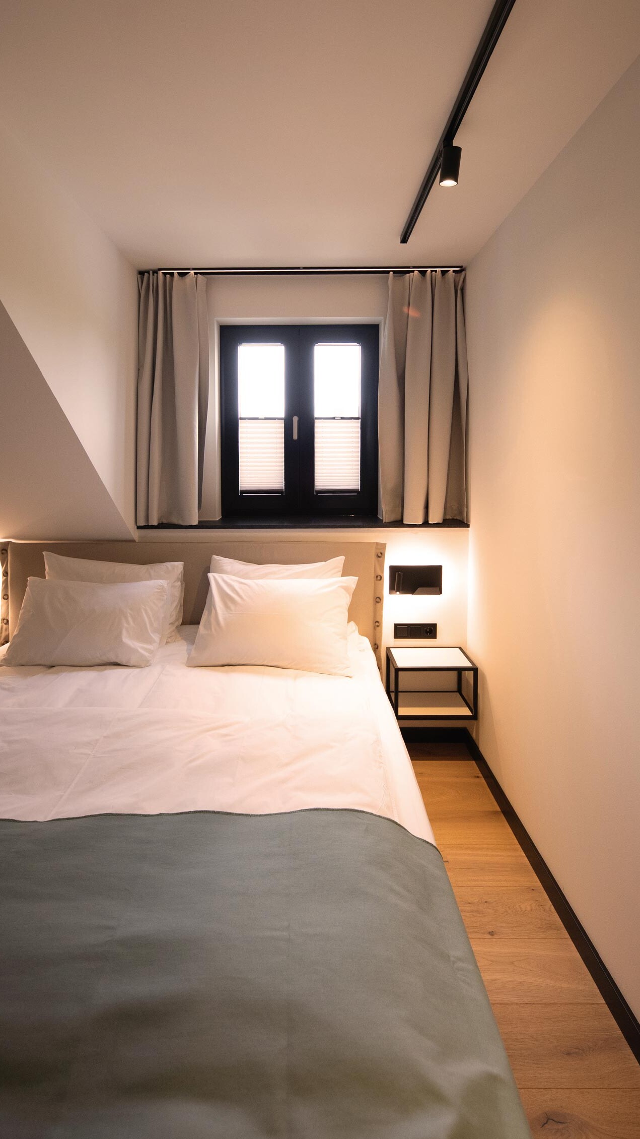 Hotelzimmer mit Beleuchtung und Fenster über dem Bett