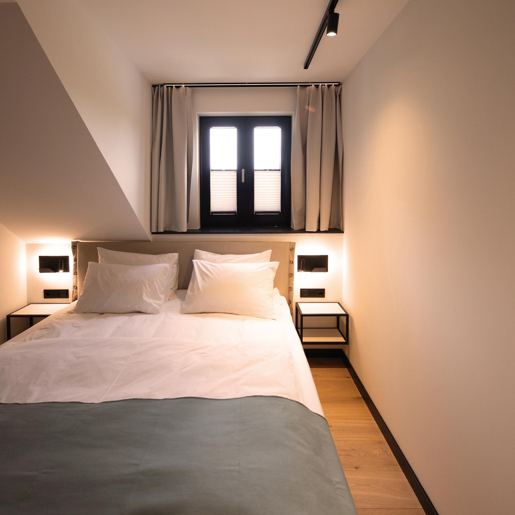 Hotelzimmer mit Beleuchtung und Fenster über dem Bett